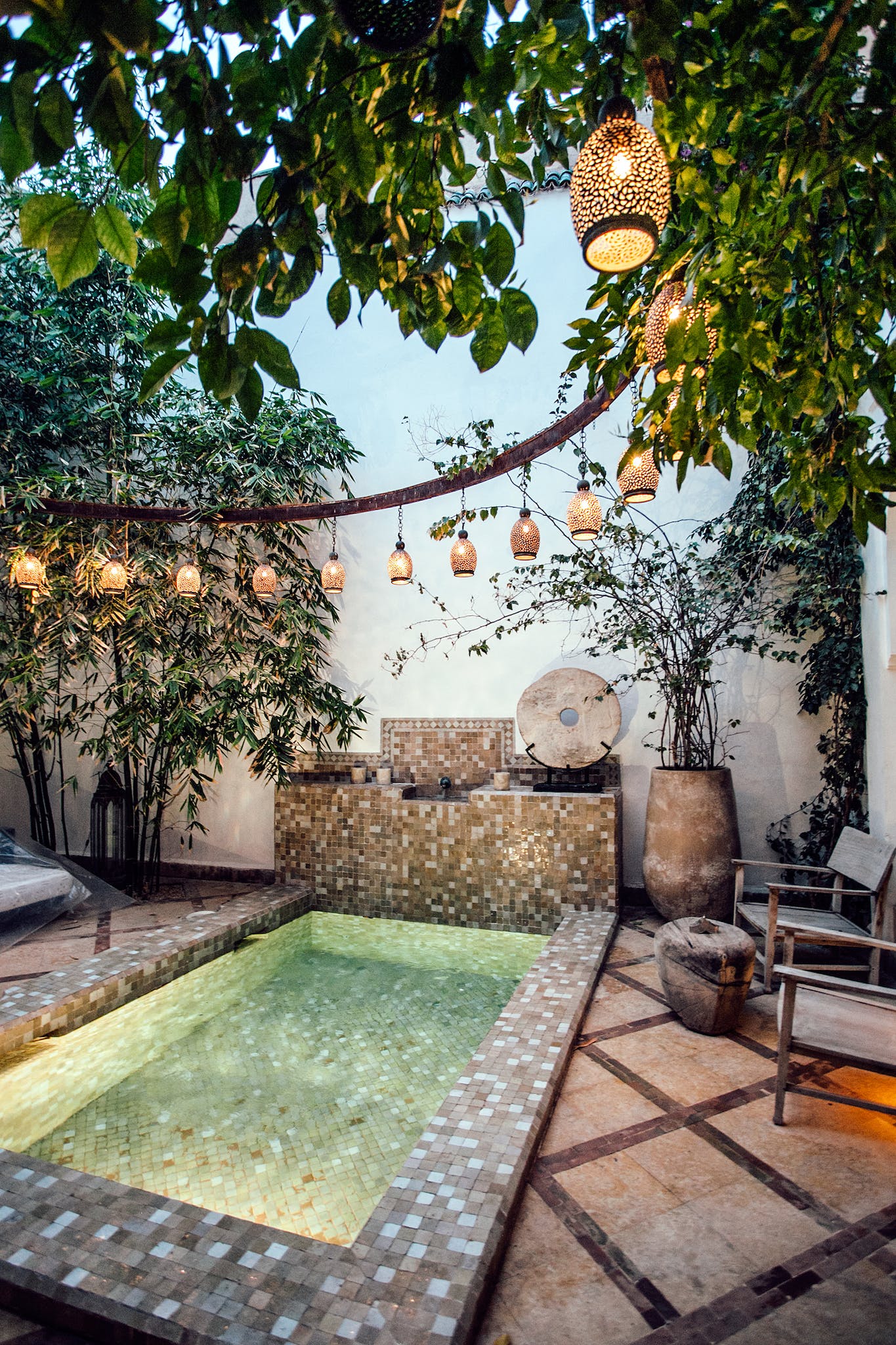 Traditional oriental hammam pool on exotic resort spa terrace decorated with lush plants  and stylish lanterns